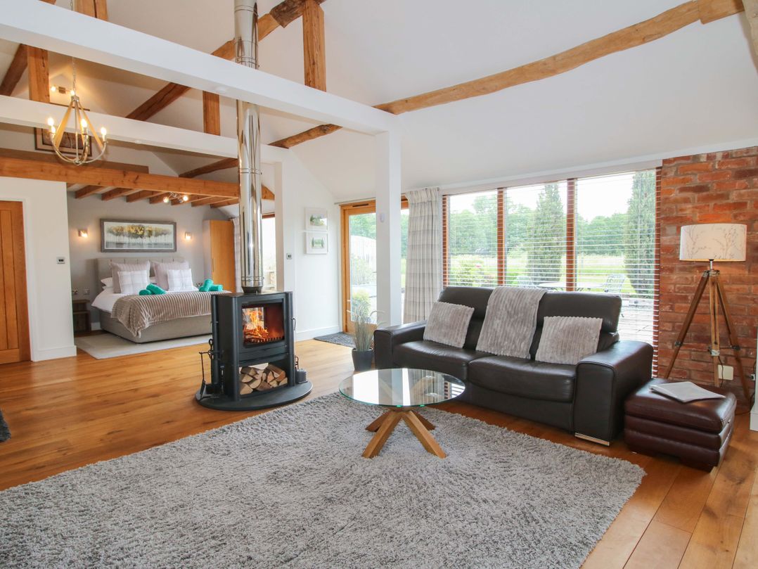 A living room with a wood stove and sofa at Meeson View in Meeson near Waters Upton