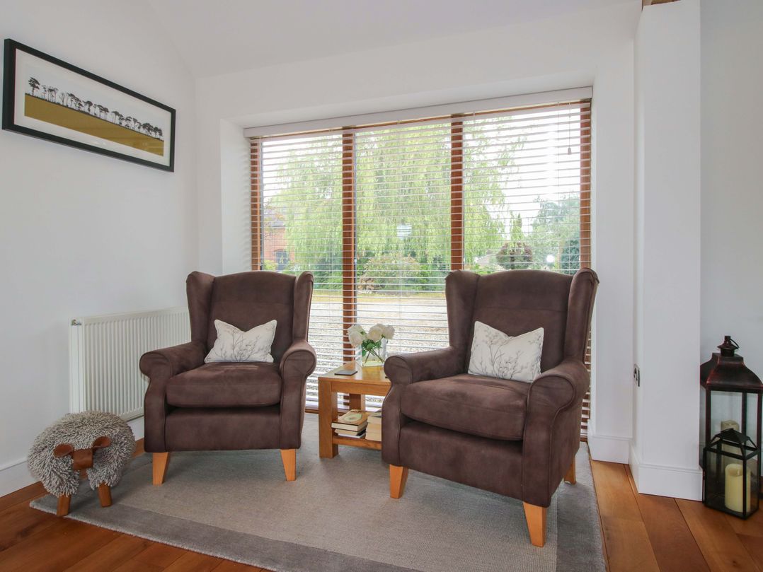 A living room with two chairs and a table at Meeson View in Meeson near Waters Upton