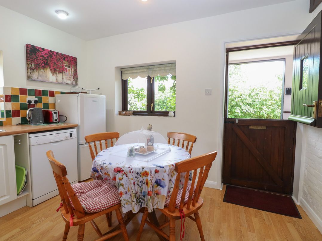 A kitchen with a table and chairs at Lowbrook Cottage in Dickleburgh near Diss