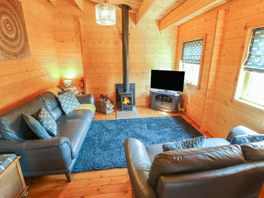 A living room with a fireplace and sofa at Tythe Lodge – Hot Tub Retreat in Rural Lincolnshire | Family-Friendly Lodge Near Heckington