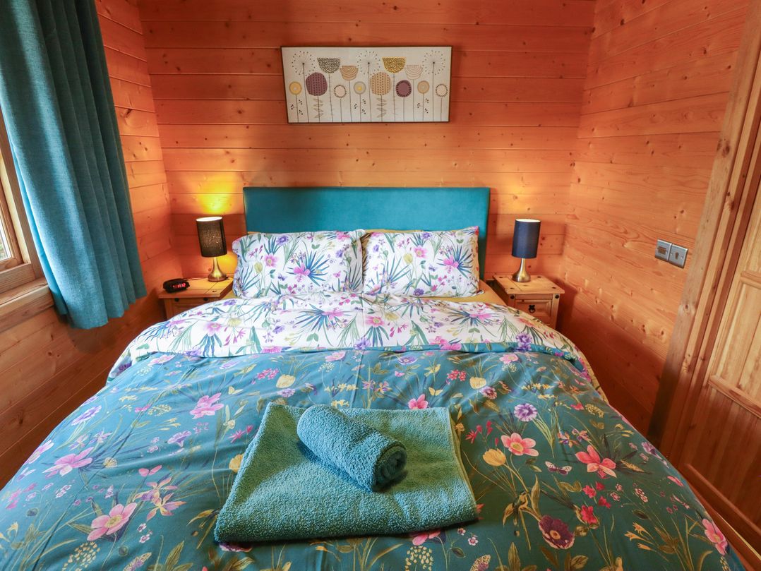 A bedroom with a bed and bedside lamps at Tythe Lodge – Hot Tub Retreat in Rural Lincolnshire | Family-Friendly Lodge Near Heckington