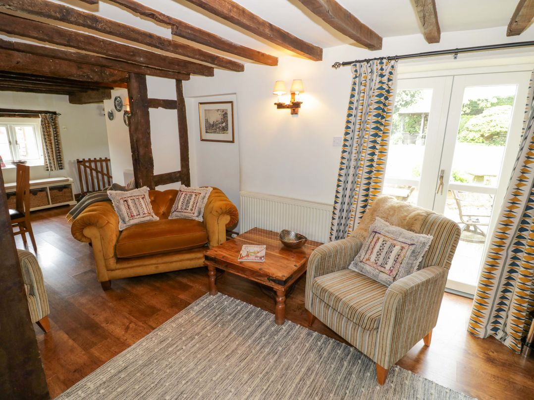 A living room with a sofa and armchair at Elmhurst Cottage in Lower Quinton