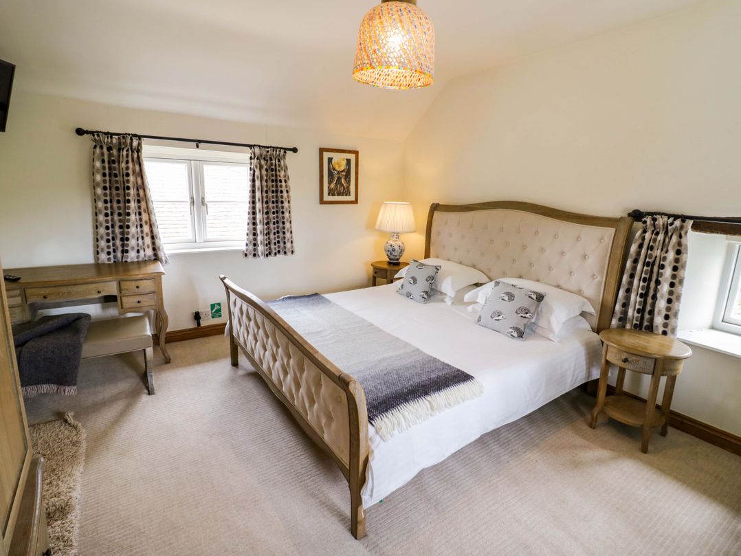 A bedroom with a bed and desk at Elmhurst Cottage in Lower Quinton
