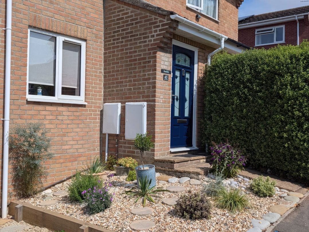 A front entrance with plants and a blue door at Seahills Lyme Regis