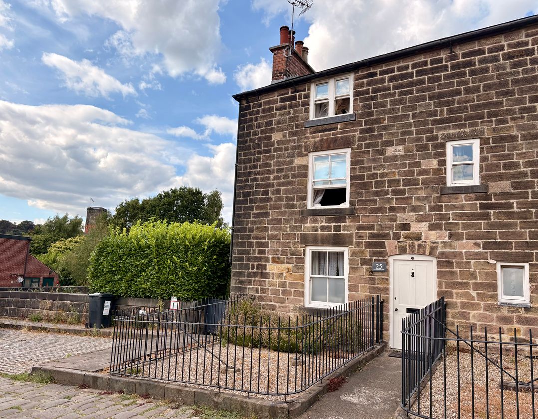A house with stone walls and a front door at Coupling Cottage in Belper