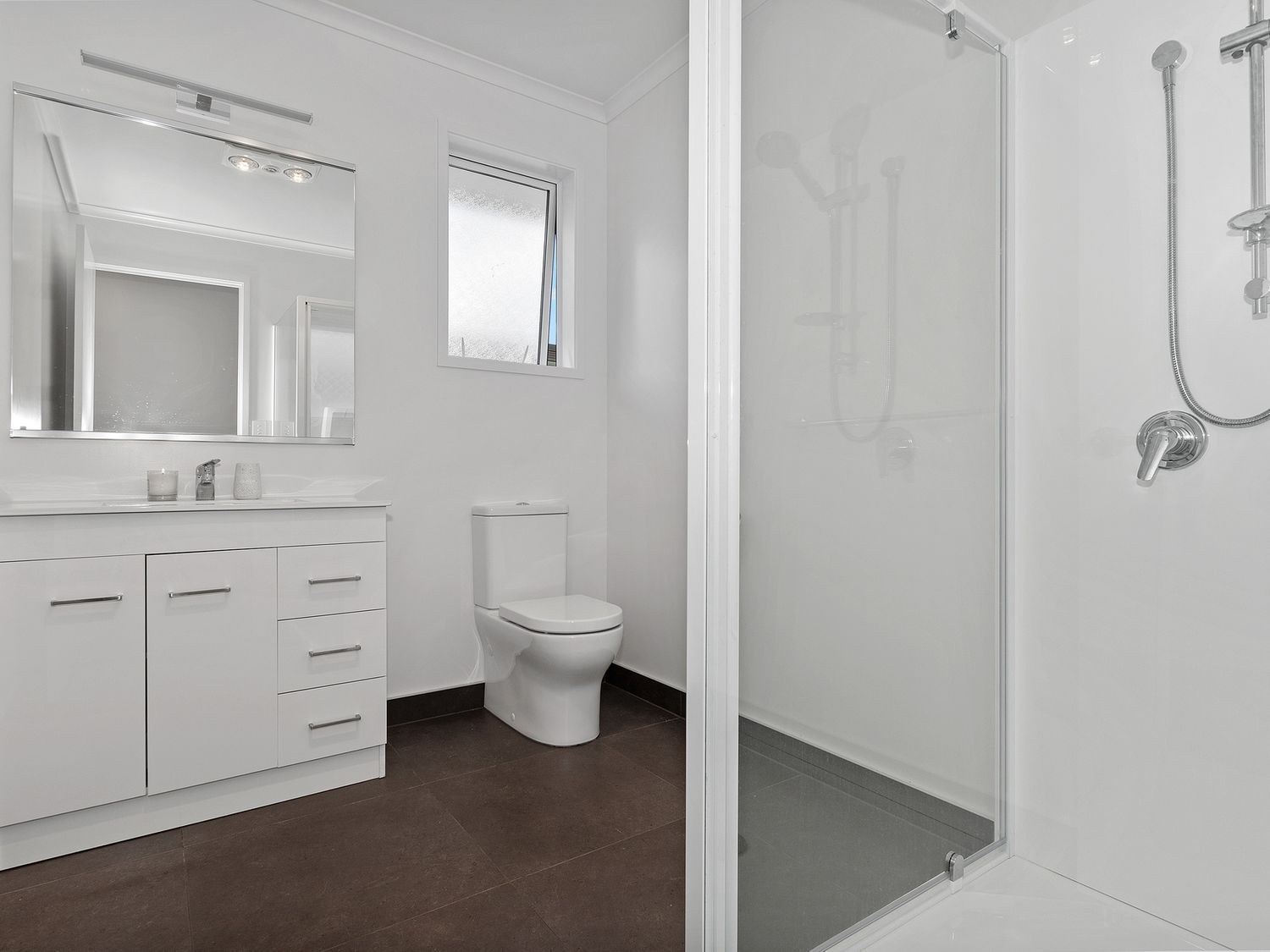A bathroom with a shower, toilet, vanity with sink and mirror at The Platinum Rendezvous - Matapouri Holiday Home in Matapouri