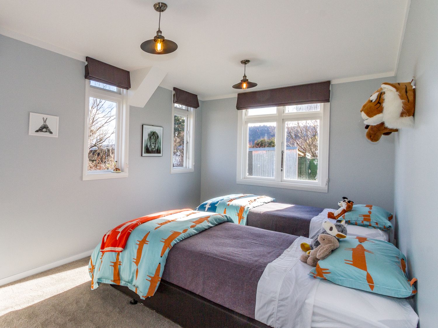 A bedroom with two single beds with animal themed bedding and stuffed toys at Ohakune Barracks Ohakune
