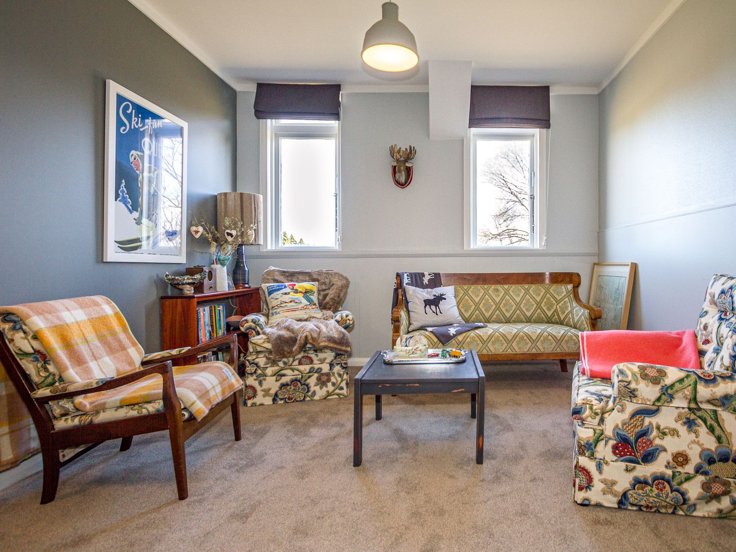 A sitting room with armchairs a sofa a coffee table and a bookcase at Ohakune Barracks Ohakune