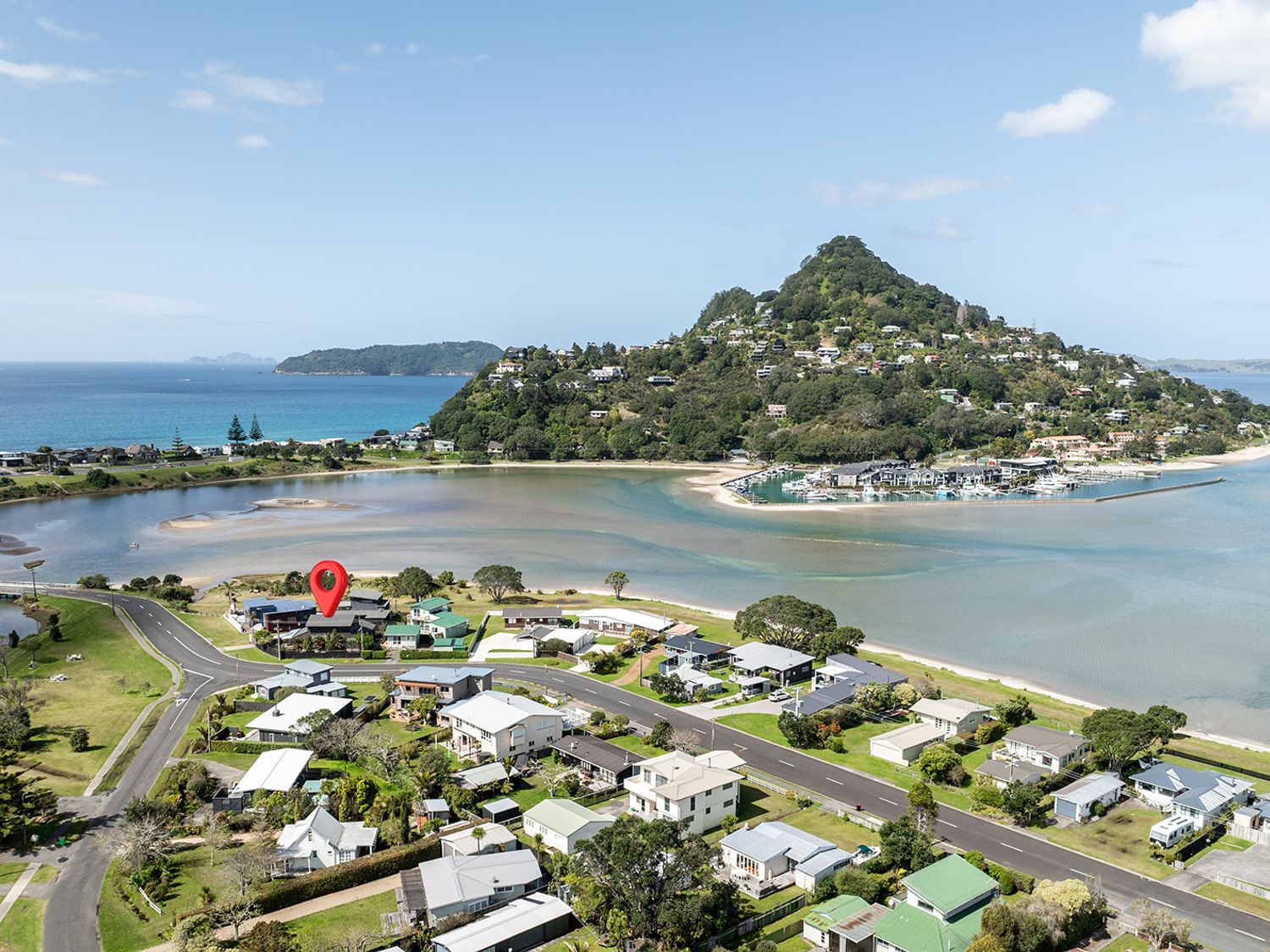 An outdoor view of a coastal area with houses and a mountain at Manaia Magic - Tairua Holiday Home in Tairua