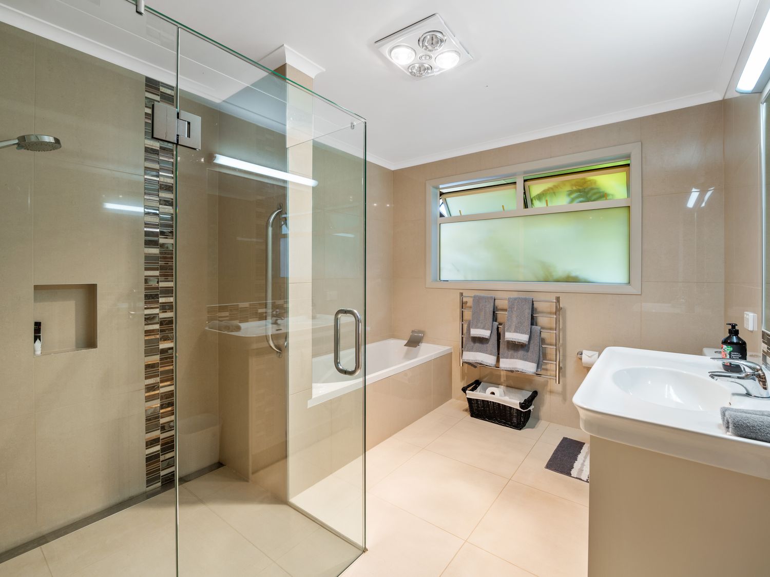 A bathroom with a glass shower enclosure bathtub towels on a rack and a sink at RidgeRaj - Kerikeri Holiday Home in Kerikeri