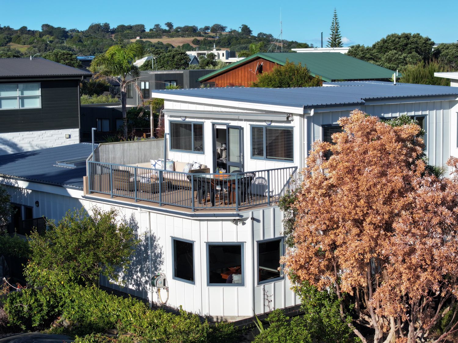 An outdoor balcony with a table and chairs at Omaha Beach House - Omaha Holiday Home