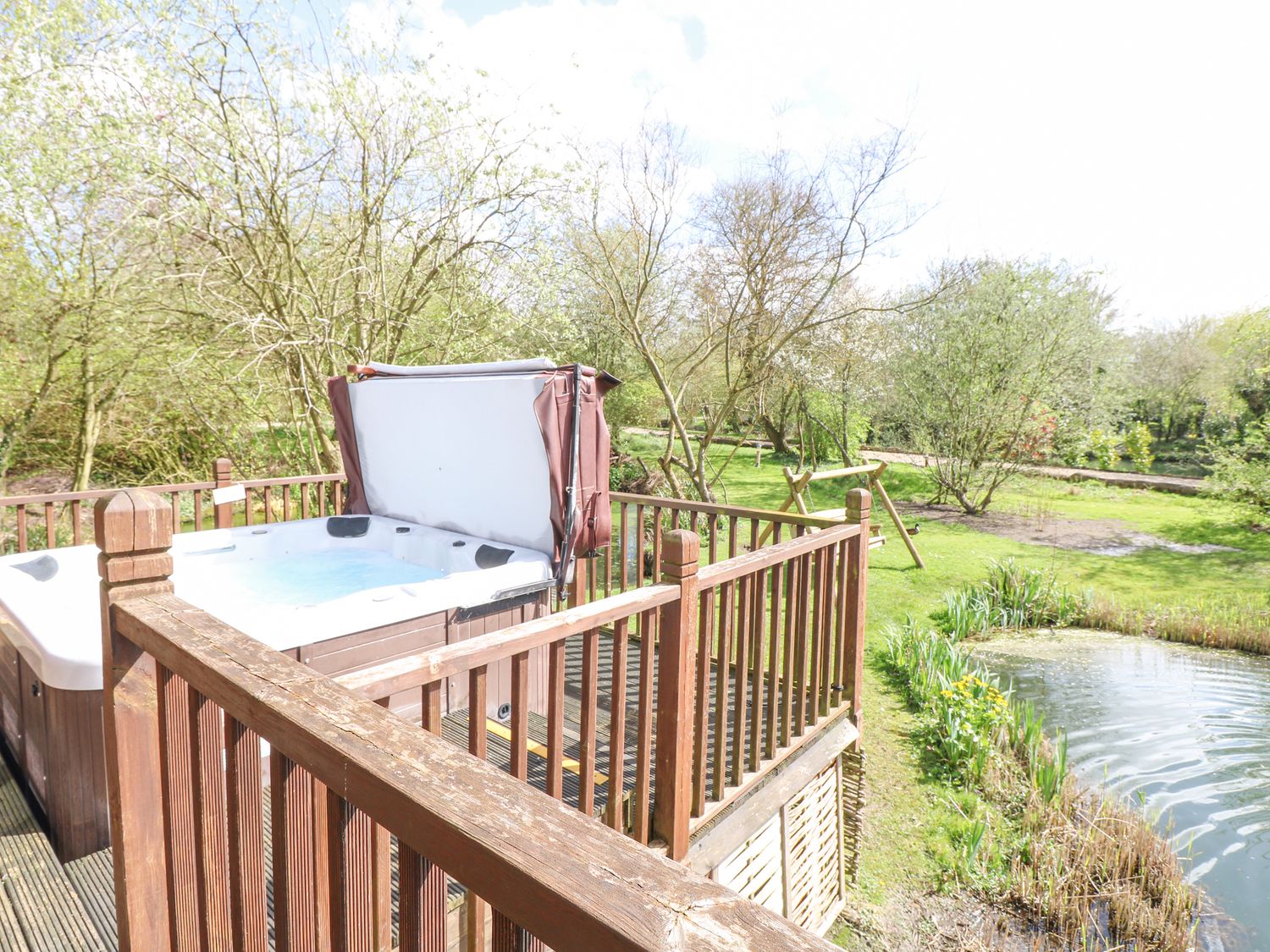 Wagtail Lodge in Badwell Ash in Suffolk. Lakeside lodge. Lovely views. Decking with hot tub and BBQ.