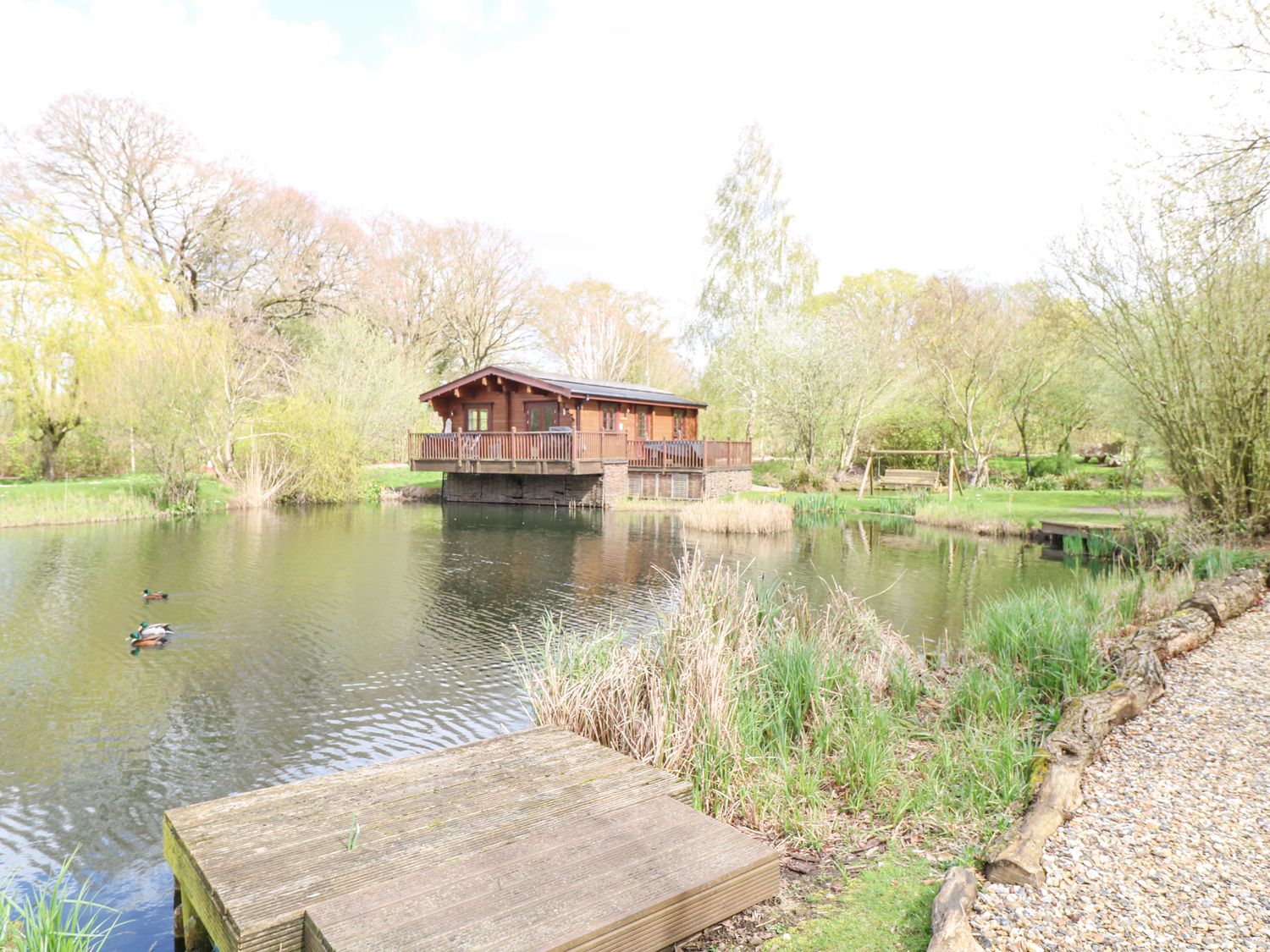 Wagtail Lodge in Badwell Ash in Suffolk. Lakeside lodge. Lovely views. Decking with hot tub and BBQ.