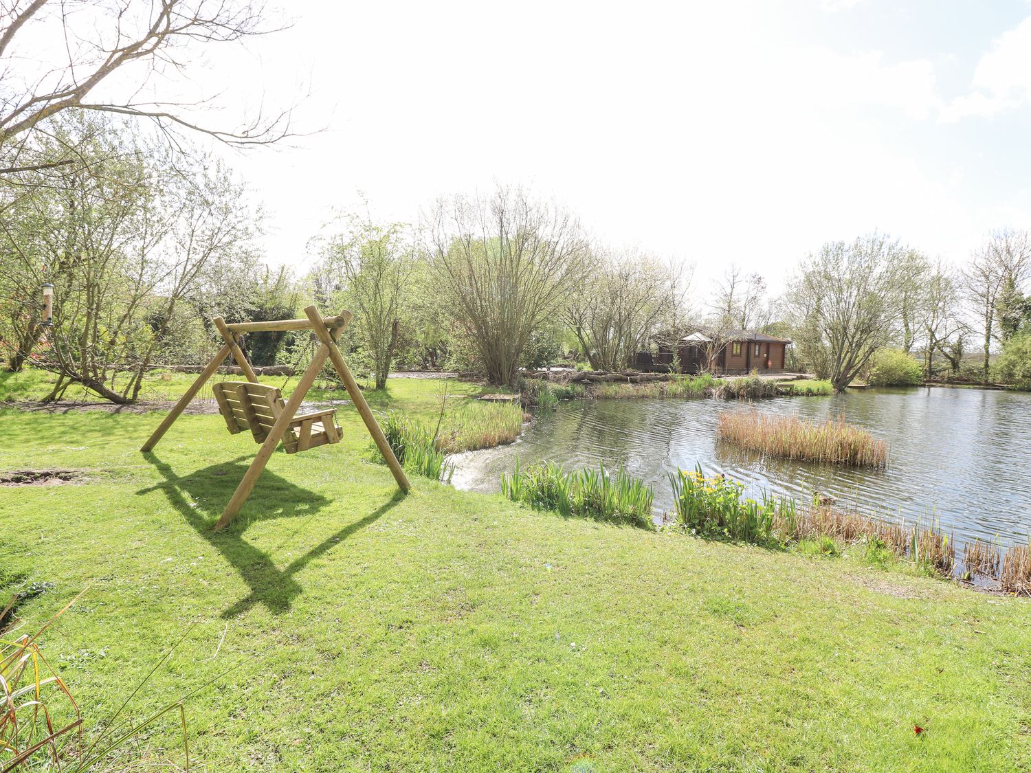 Wagtail Lodge in Badwell Ash in Suffolk. Lakeside lodge. Lovely views. Decking with hot tub and BBQ.