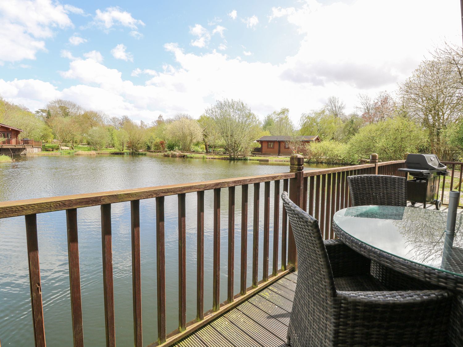 Woodpecker Lodge in Badwell Ash, Suffolk. Adults only. Decking with hot tub and BBQ. Lakeside lodge.