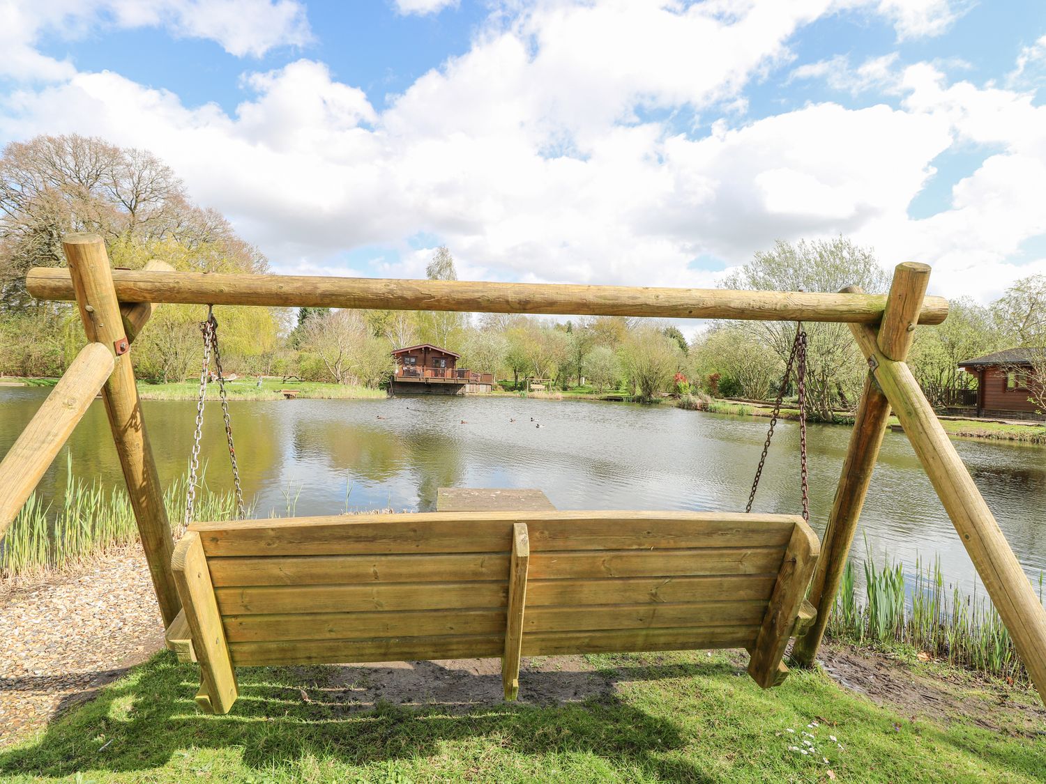 Woodpecker Lodge in Badwell Ash, Suffolk. Adults only. Decking with hot tub and BBQ. Lakeside lodge.