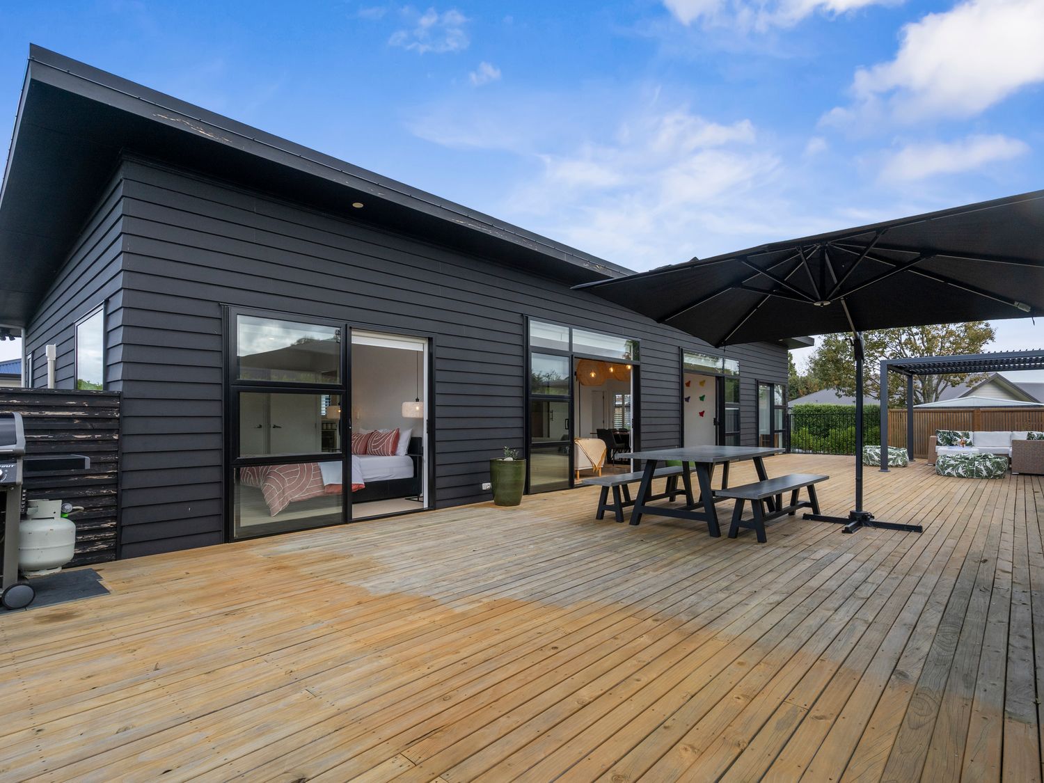 An outdoor area with a table and chairs at House Naomi - Martinborough Holiday Home in Martinborough