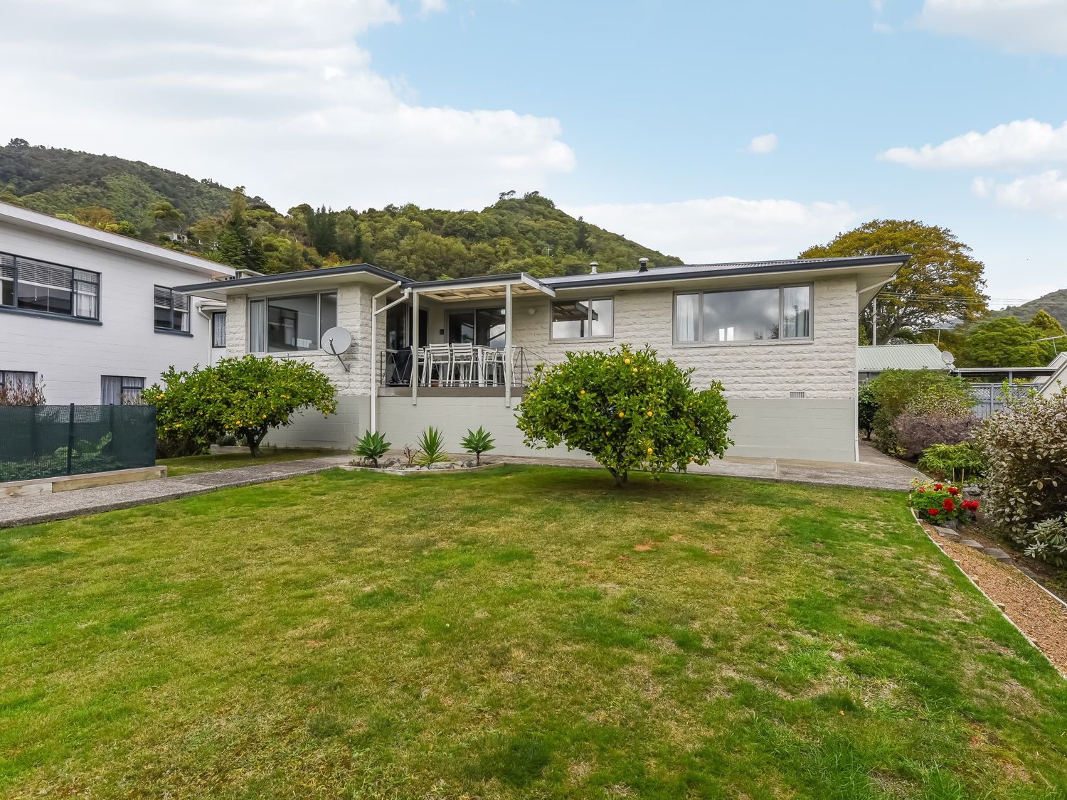 A single story house with a lawn and trees in front at The White House - Picton Retreat in Picton