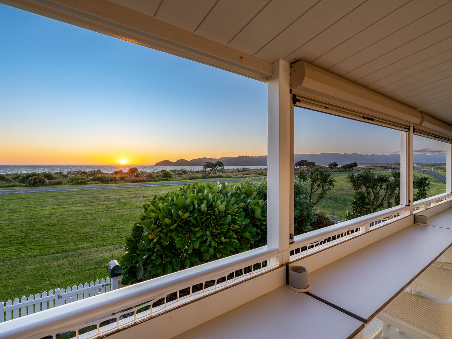 A view of the sea and sunset from an outdoor area at Sunset Haven - Mahia Holiday Home in Mahia Peninsula
