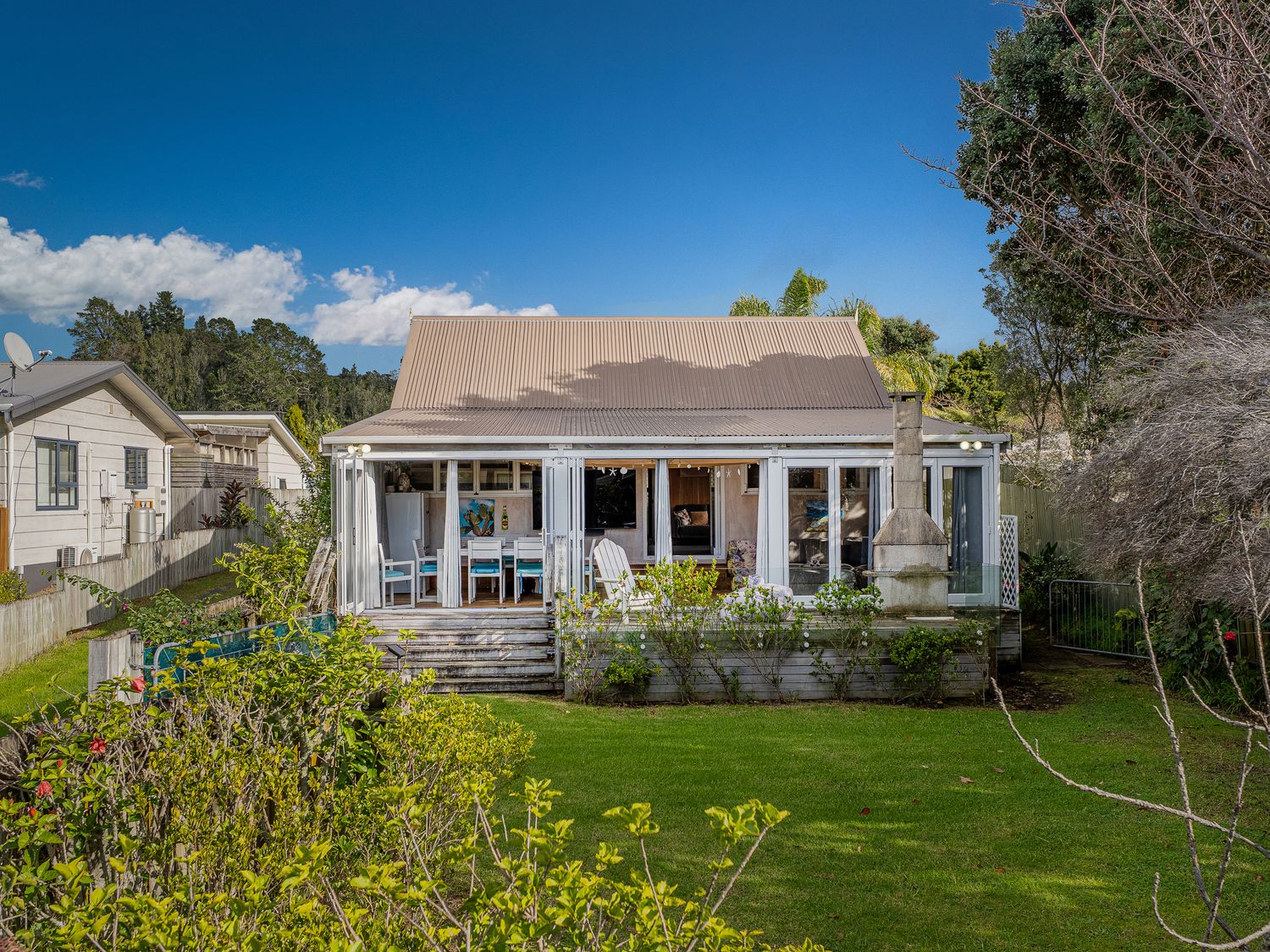 A house with a deck and garden at Home Away From Home In Whangamata