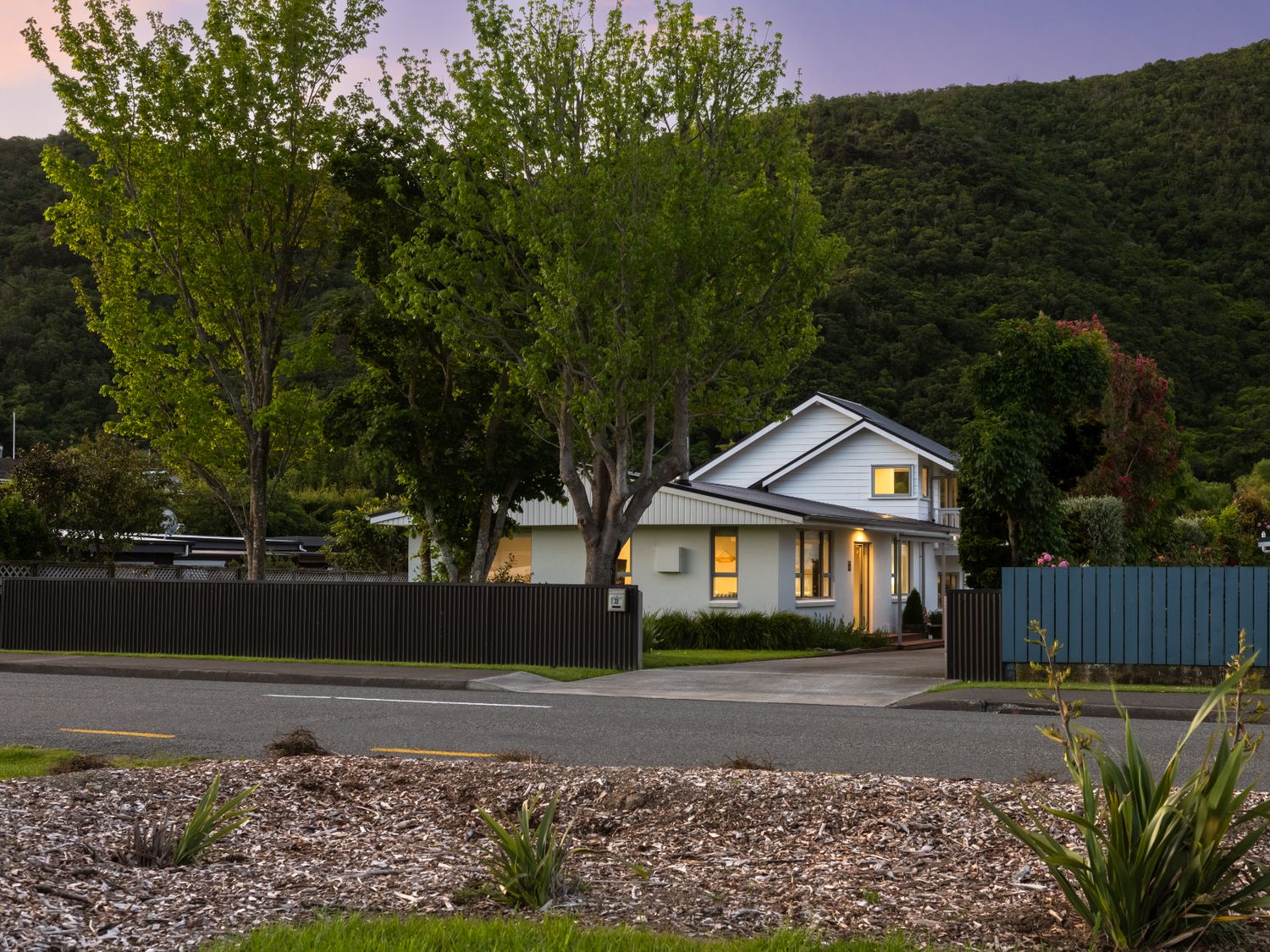 A house with trees and fence at Bayview Haven - Waikawa Retreat in Picton