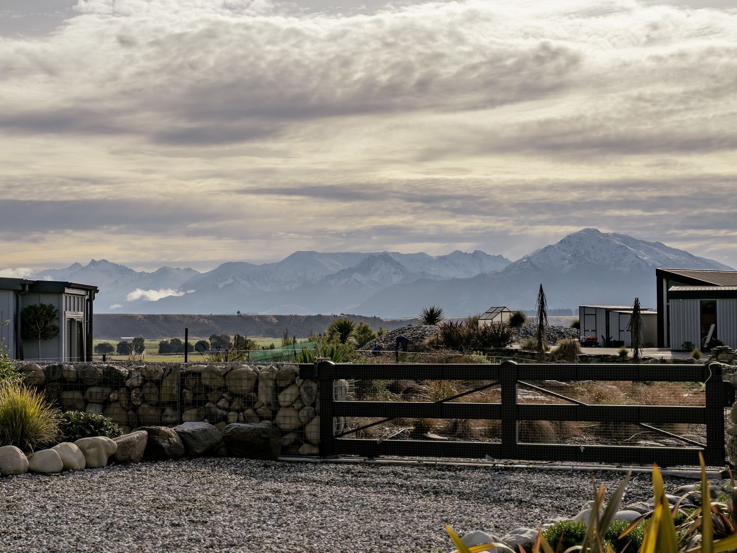 A view of mountains and buildings at Eight on Jackson - Luggate Holiday Home