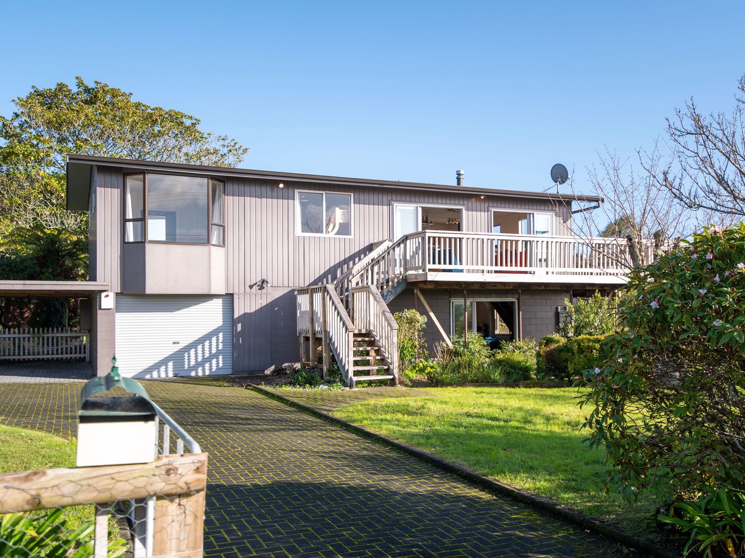 A house with a balcony and garage door at Rotorua Holiday Home Rotorua