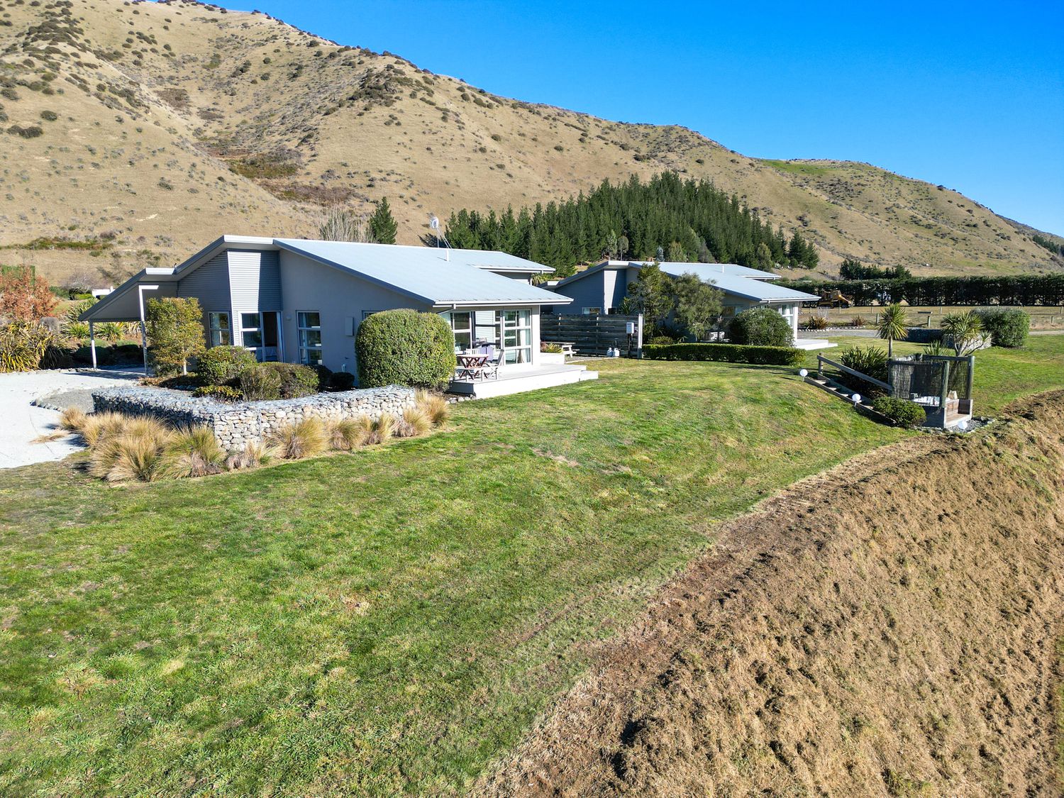 A house surrounded by grass and trees at Tussock Cottage - Canterbury Holiday Home, Canterbury