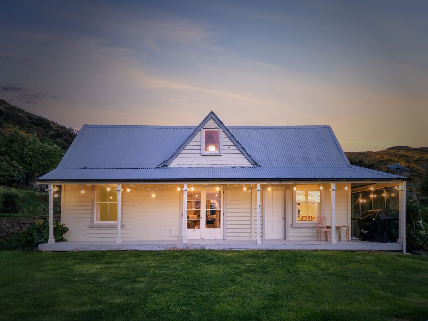 A house with a front porch and outdoor lights at Akaroa Holiday Home