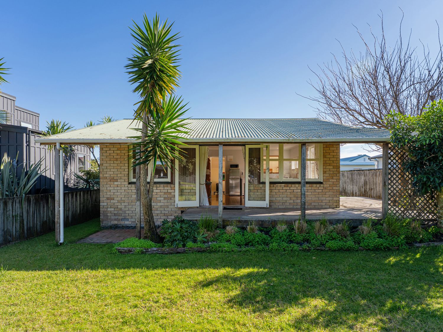 A house with a garden and trees at They Carolyn - Whangamata Holiday Home Whangamata