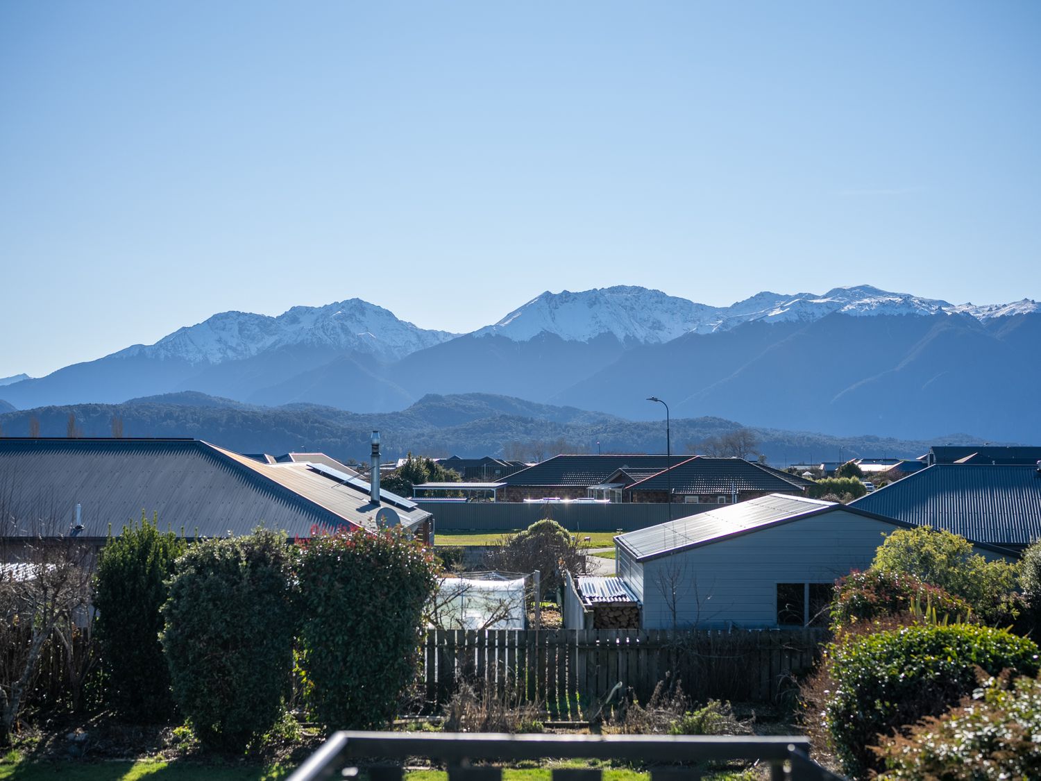 A view of mountains and houses from a balcony at Four Peaks on Matai - Te Anau Holiday Home Te Anau