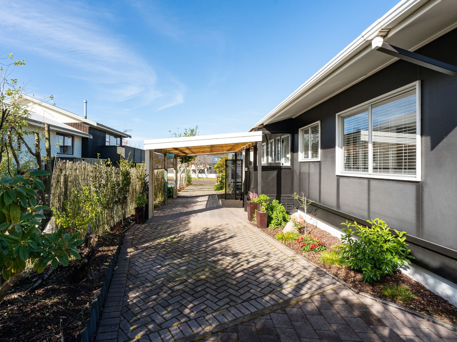 A pathway beside a building with plants and a fence at Taupo - Holiday Home