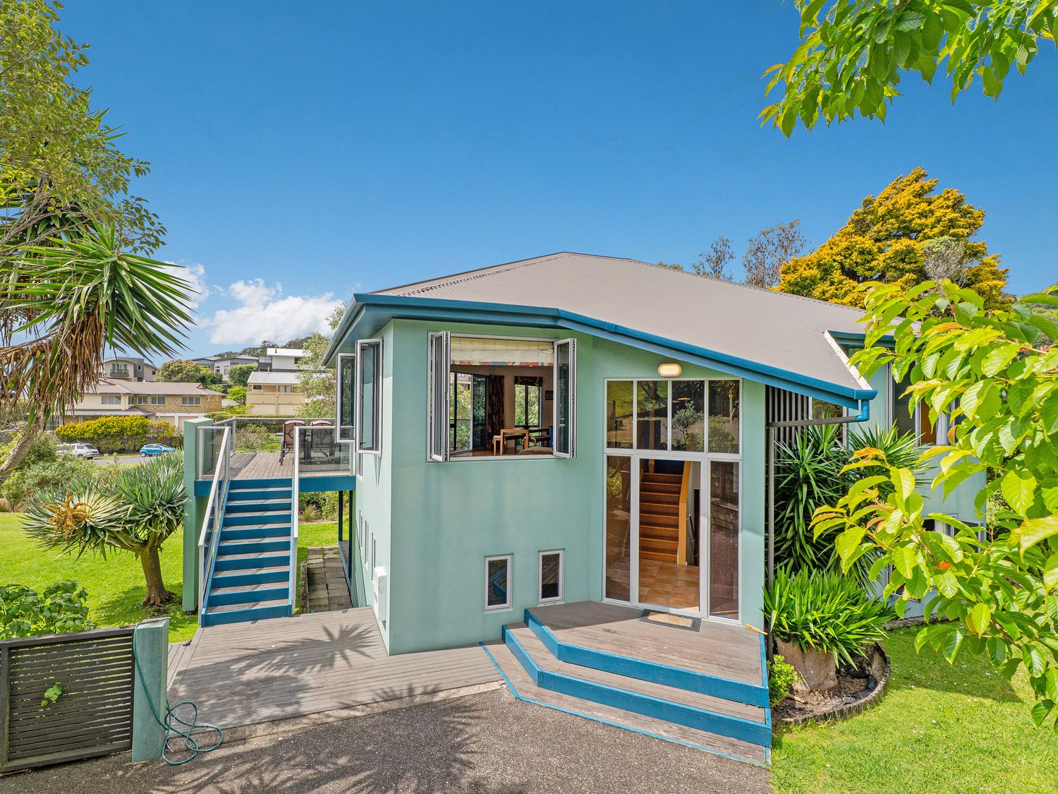 A house with stairs and a garden at Whangamata