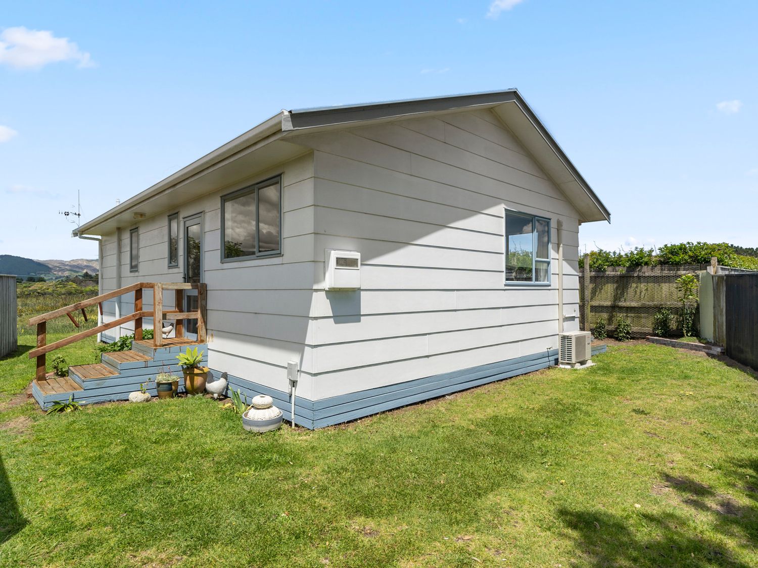 An exterior view of a house with steps and garden at Kapiti Breeze - Waikanae Beach Holiday Home