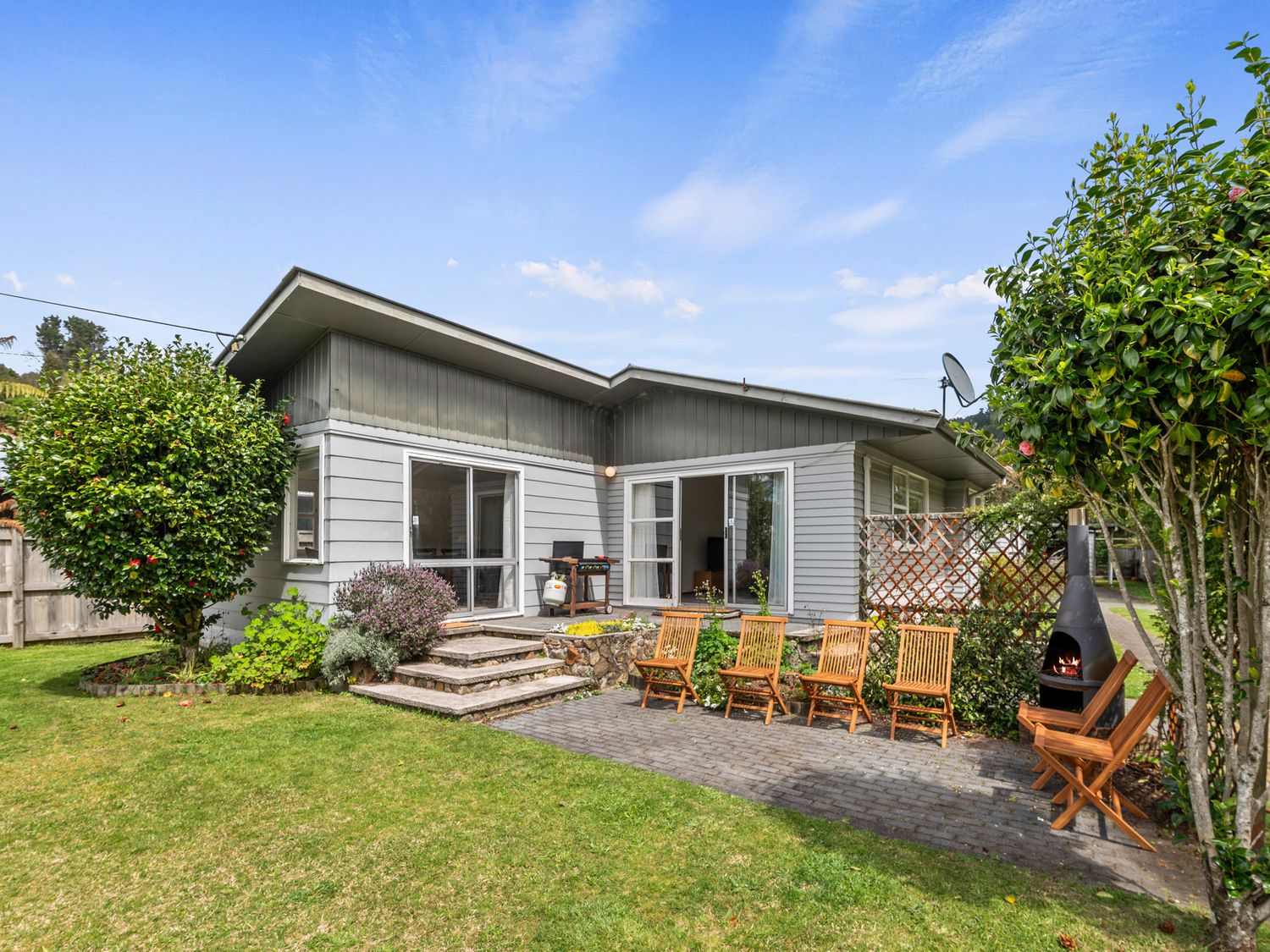 An outdoor area with chairs and a house at Lake Okareka Holiday Home in Rotorua