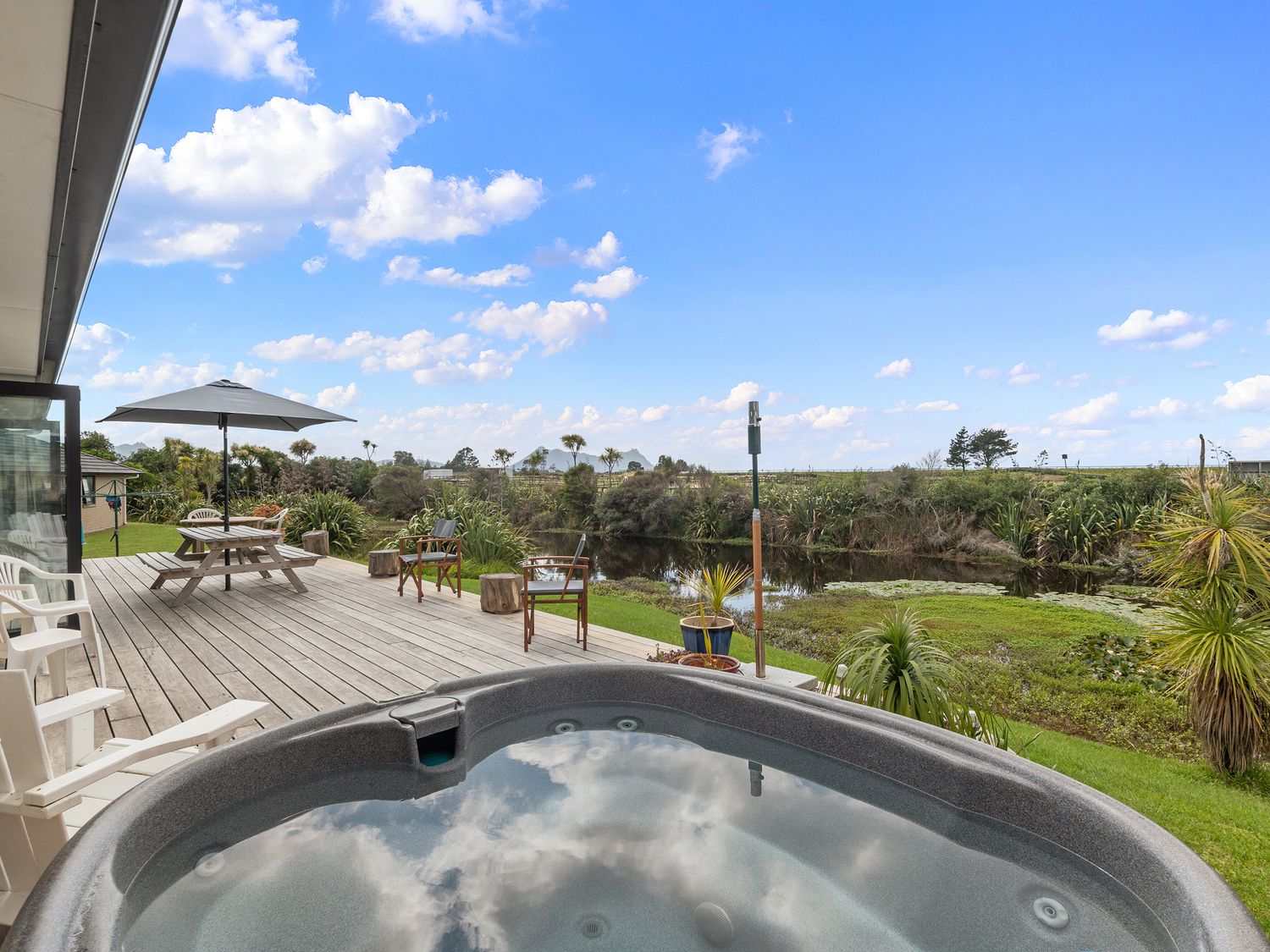 An outdoor space with a hot tub and seating area at Home Away From Home - Ruakaka