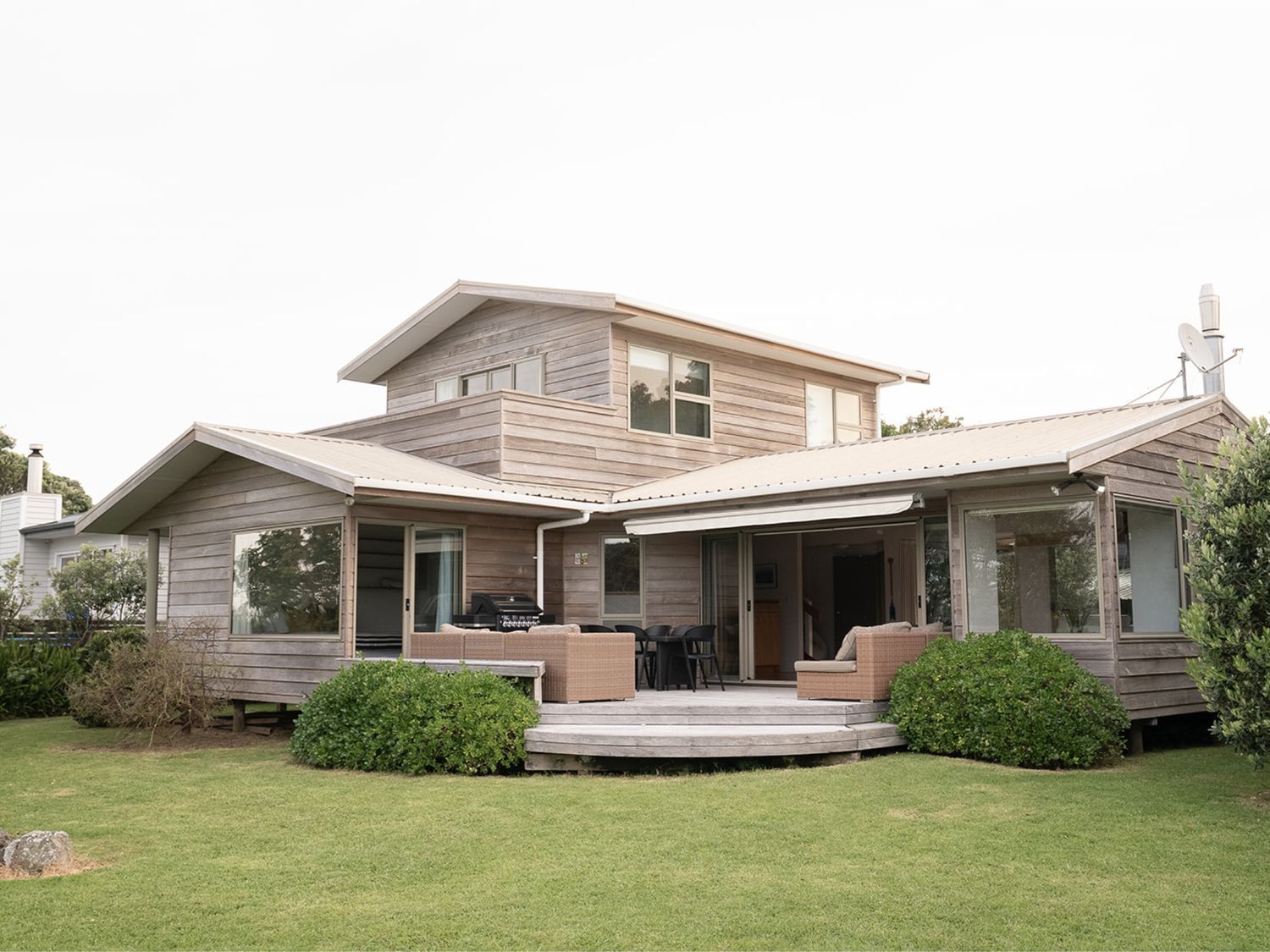 A house with a porch and garden at Tranquil Waterfront Getaway - Point Wells Warkworth