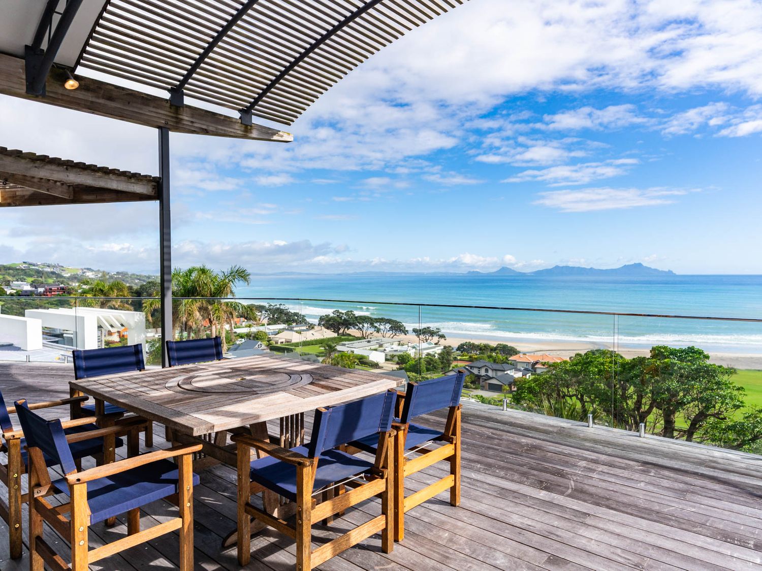 An outdoor terrace with a table and chairs overlooking the ocean at Langscape - Langs Beach Holiday Home Langs Beach