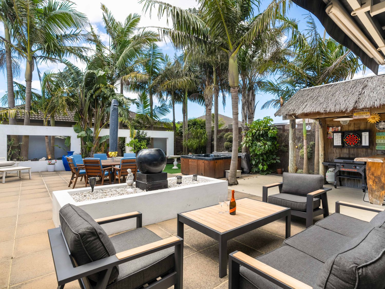 An outdoor area with seating and a spa at Papamoa Beach in Papamoa