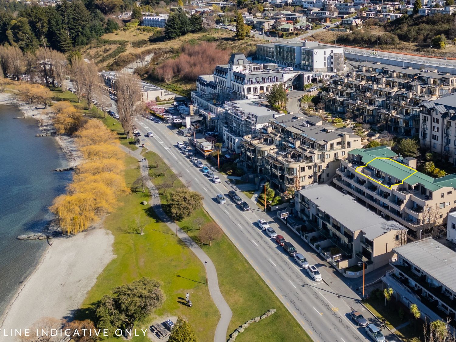 An aerial view of lakeside buildings and a park at Lakefront Penthouse - Central Queenstown Holiday Home, Queenstown