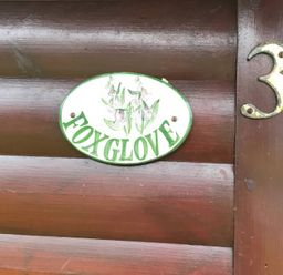 A sign displaying the name Foxglove attached to a wooden cabin at Foxglove Lodge Saltburn-By-The-Sea