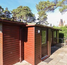 An exterior view of a wooden cabin with surrounding trees at Foxglove Lodge Saltburn-By-The-Sea