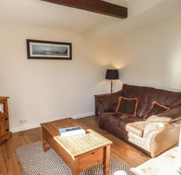 A living room with a sofa, coffee table, and television at Foxglove Lodge Saltburn-By-The-Sea