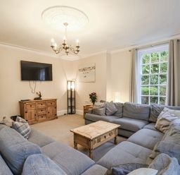A living room with a sectional sofa and television at The Manor House in Scarborough