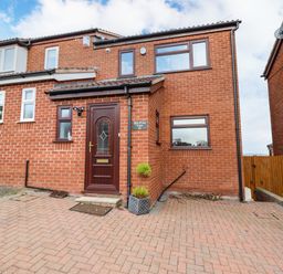 A brick house with a brown front door and driveway at Sea-Prize View in Old Colwyn