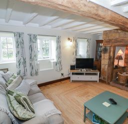 A living room with a sofa and television at Priors Mead Claydon near Cropredy