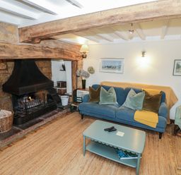 A living room with a fireplace and a sofa at Priors Mead in Claydon near Cropredy
