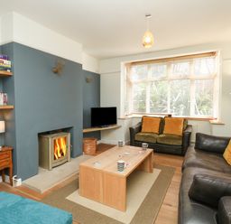 A living room with a wood stove fireplace sofas and a coffee table at Sandsfoot Rest in Weymouth