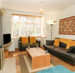 A living room with two leather sofas and a wooden coffee table at Sandsfoot Rest in Weymouth