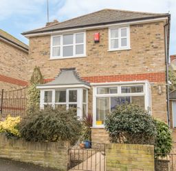 A two story brick house with white framed windows bushes and a small front garden at Casa Carmen Weymouth